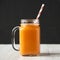 Homemade Mango Carrot Smoothie in a glass jar mug, side view