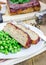 Homemade meatloaf garnished with green peas