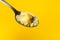 Homemade melted butter on a spoon. Ghee. Ayurveda. On a Colored yellow background