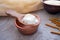 Homemade milk kefir grains on a wooden spoon above a clay bowl o