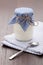 Homemade milk yogurt in glass pot and spoon on table