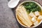 Homemade miso soup with tofu cheese, enoki mushrooms, wakame seaweed close-up in a bowl. Horizontal top view