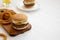 Homemade Mississippi Slug Burgers with onion rings and glass of cold beer on a white wooden background, side view. Copy space