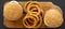 Homemade Mississippi Slug Burgers with onion rings on a rustic wooden board on a black surface, top view. Flat lay, overhead, from