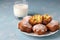 Homemade muffins with dried apricots sprinkled with powdered sugar and a glass of milk on a light blue background