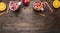 Homemade mulled wine with apple, orange, cinnamon, cloves and other ingredients have been laid out around a wooden rustic backg