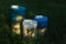 Homemade multi-colored candles with concrete on a background of green grass. handmade decor close-up. Details of a colored cube