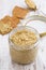 Homemade mustard in a glass jar and crackers, top view