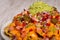 Homemade nachos with vegetable salad hash and guacamole. Closed image with copy space