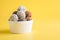 Homemade natural energy balls, vegan chocolate truffle with cacao, coconut on yellow background. Healthy food for children, sweets