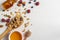 Homemade natural granola with honey, berries and nuts in a wooden spoon on white background