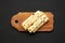 Homemade Norwegian Potato Flatbread Lefse with Butter and Sugar on a rustic wooden board on a black background, top view.