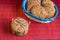 homemade oat cookies with sunflower seeds in and rear blue checkered basket on wooden table