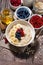 Homemade oatmeal with berries on wooden background, vertical top view