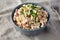 Homemade Olivier salad in a Bowl on a white wooden background, side view