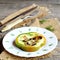 Homemade omelet with mushrooms in green pepper. Original eggs omelet on a plate, fork and knife on old wooden background