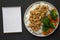 Homemade Orange Chicken with White Rice, Broccoli and Carrot, blank notepad on a black surface, top view. Flat lay, overhead, from