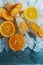 Homemade orange and peach popsicles with ice and citrus slices on light background