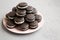 Homemade Oreos on a pink plate on a gray background, side view. Space for text