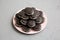 Homemade Oreos on a pink plate on a gray surface, low angle view