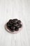 Homemade Oreos on a pink plate on a white wooden background, side view