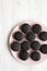 Homemade Oreos on a pink plate on a white wooden background, top view. Flat lay, overhead, from above. Copy space