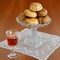 Homemade 'panellets' in vintage glass stand, lace doily, vintage sweet wine small glass. Copy space.