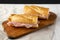Homemade Parisian Jambon-Beurre Sandwich on a rustic wooden board, side view