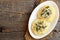 Homemade pasta with mushrooms, cheese and dill on a plate with empty space for text