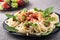 Homemade pasta with stewed chicken and vegetable salad closeup