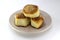 Homemade pastries, ruddy buns with sesame seeds on a pearl plate on a white background