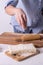 Homemade pastries: a woman sprinkles flour on the dough.