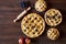 Homemade pastry apple pie bakery products on dark wooden kitchen table with raisins and apples. Traditional dessert on