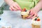 Homemade pastry. Woman cooking cakes. Tasty birthday cupcake on table. Confectioner decorate cupcakes with cream cheese and