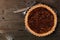 Homemade pecan pie, top view over wood