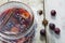 Homemade pickled plums in a glass jar on rustic wood