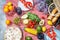 Homemade picnic with fresh fruits, vegetables, salad, orange juice, flowers and baguette on a red plaid. Beautiful still life