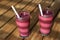 Homemade Pink / Purple Berry and Vegetable Smoothie on Wooden Balcony Floor