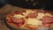 Homemade pizza with ham and cheese lies on parchment close-up view super on the side. Homemade fast food background