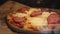 Homemade pizza with ham and cheese lies on parchment close-up view super on the side. Homemade fast food background