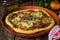 Homemade pizza with zaatar, tomatoes, onion and cheese on wooden background. Eastern cuisine. Selective focus