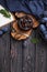 Homemade plum jam in a glass jar and fresh blue plums in a bowl on a dark rustic wooden background with copy space top view.