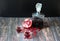 Homemade pomegranate liqueur in a bottle and two glasses and a broken fruit with a scattering of seeds on a wooden table