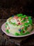 Homemade poppy cake with nut biscuit and custard cream decorated sweets candy on wooden background.