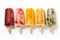 Homemade popsicles with different flavors on white background, top view