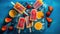 Homemade popsicles with fresh strawberries and ice cubes on blue background.