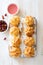 Homemade profiteroles on wooden cutting board close up