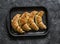 Homemade puff pastry walnuts brown sugar croissants on a baking sheet on a dark background, top view