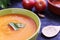 Homemade pumpkin cream on a black wooden table next to some tomatoes, garlic and a wooden spoon. Empty copy space