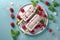 Homemade raspberry yogurt popsicles on a plate with ice and fresh berries, generative AI